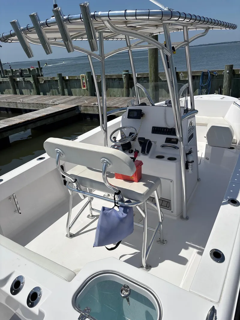 Slide: The Image of 2024 Aquasport 2200 Center Console boat docked, featuring a sleek helm and seating area. - 2
