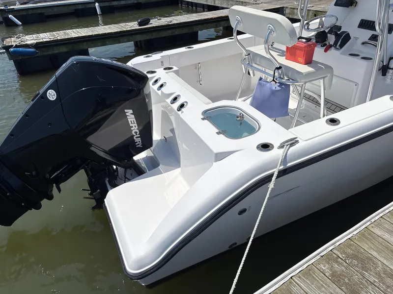 Slide: The Image of 2024 Aquasport 2200 Center Console boat docked, featuring a Mercury engine. - 3
