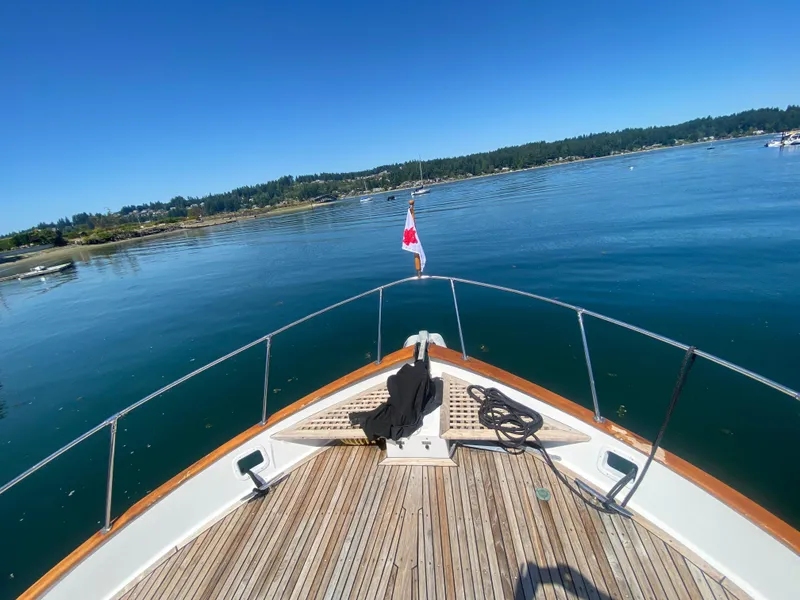 Slide: The Image of Bow of 1982 C & L Sea Ranger yacht on calm water, clear sky, Canadian flag. - 10