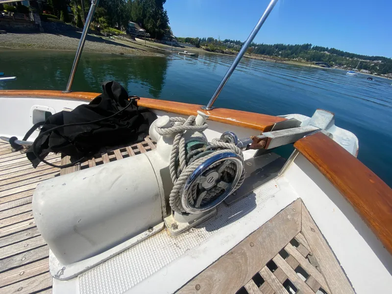 Slide: The Image of 1982 C & L Sea Ranger boat deck with anchor winch and scenic waterfront view. - 12