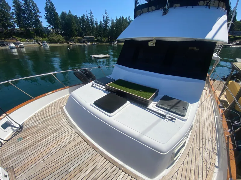 Slide: The Image of 1982 C & L Sea Ranger yacht with wooden deck, docked in a serene marina. - 14