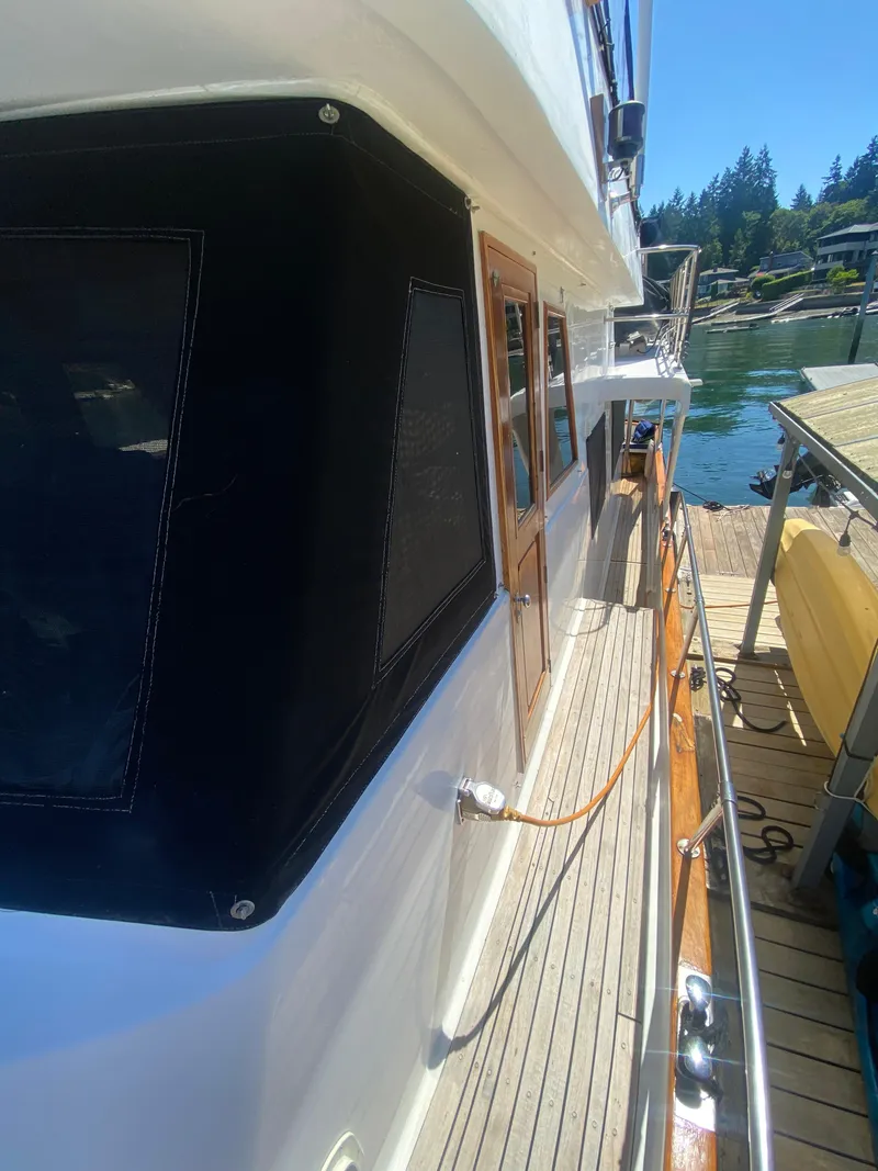 Slide: The Image of 1982 C & L Sea Ranger yacht docked, featuring wooden deck and cabin windows. - 15