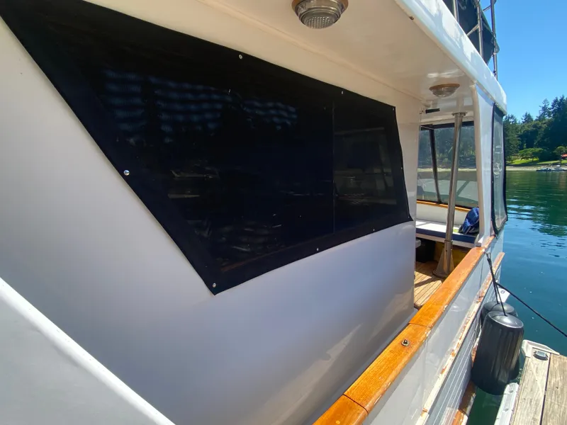 Slide: The Image of 1982 C & L Sea Ranger boat docked, featuring wooden trim and covered windows. - 16