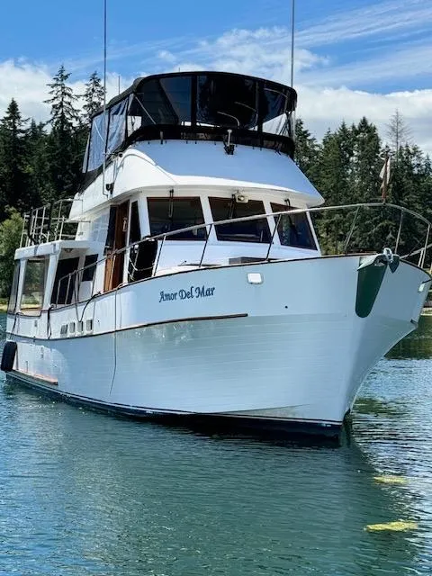 Slide: The Image of 1982 C & L Sea Ranger yacht "Amor Del Mar" on tranquil water with forested background. - 2