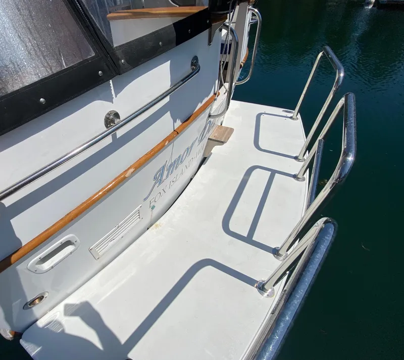 Slide: The Image of 1982 C & L Sea Ranger boat stern with railing, docked on calm water. - 24