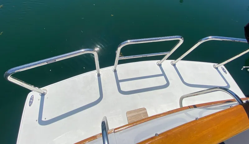 Slide: The Image of Rear deck of 1982 C & L Sea Ranger boat with metal railings over water. - 25