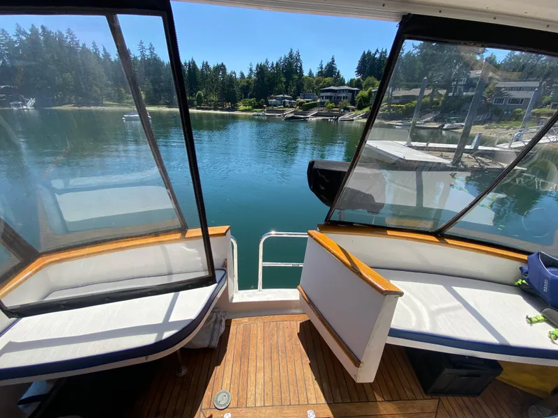 Slide: The Image of View from 1982 C & L Sea Ranger boat, overlooking serene waterfront and lush greenery. - 27