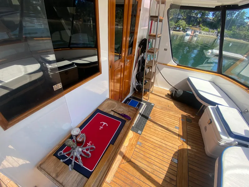 Slide: The Image of 1982 C & L Sea Ranger boat interior with wooden flooring and seating, docked by a scenic waterfront. - 28