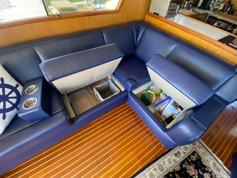 Slide: The Image of Blue leather seating with storage compartments open on a 1982 C & L Sea Ranger boat. - 33