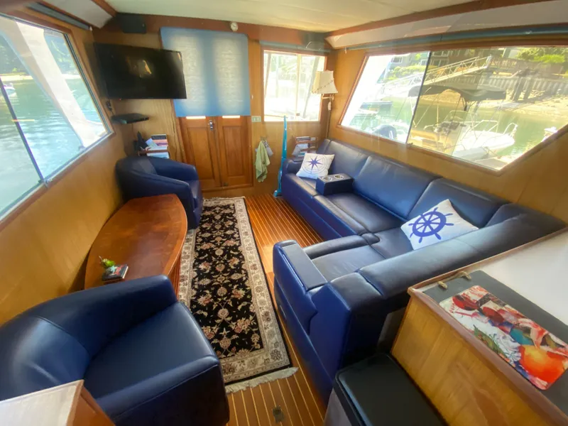Slide: The Image of Luxurious 1982 C & L Sea Ranger yacht interior with blue seating, nautical decor, and large windows. - 37