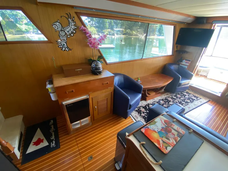 Slide: The Image of Cozy 1982 C & L Sea Ranger interior with wood paneling, blue chairs, and decorative accents. - 38