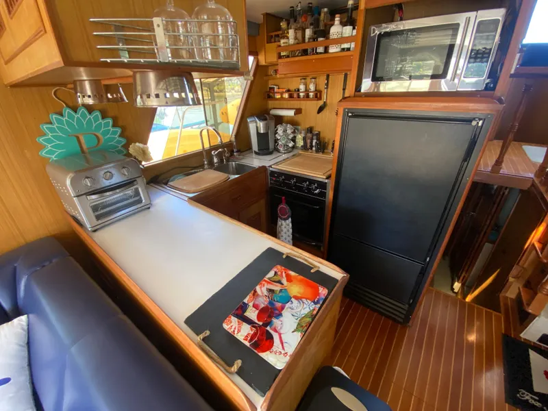 Slide: The Image of Cozy 1982 C & L Sea Ranger yacht kitchen with modern appliances and wooden interior. - 41