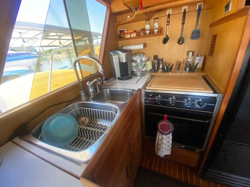 Slide: The Image of Compact kitchen in 1982 C & L Sea Ranger boat with sink, stove, and utensils. - 42