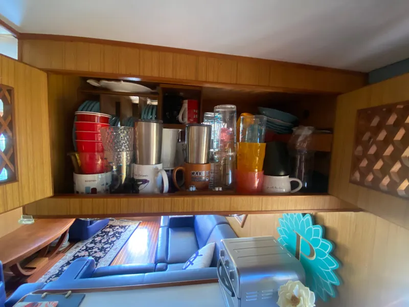 Slide: The Image of Cabinet with assorted cups and glasses inside a 1982 C & L Sea Ranger boat. - 45