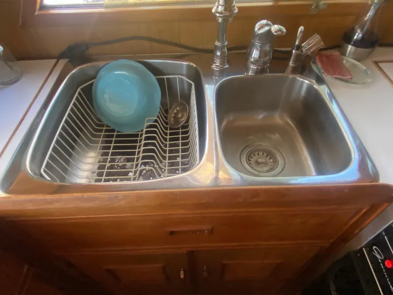 Slide: The Image of Stainless steel double sink with dishes in a 1982 C & L Sea Ranger boat. - 48
