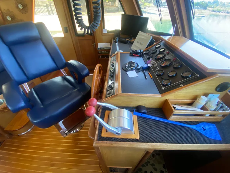 Slide: The Image of 1982 C & L Sea Ranger helm with control panel, blue captain's chair, and navigation equipment. - 54