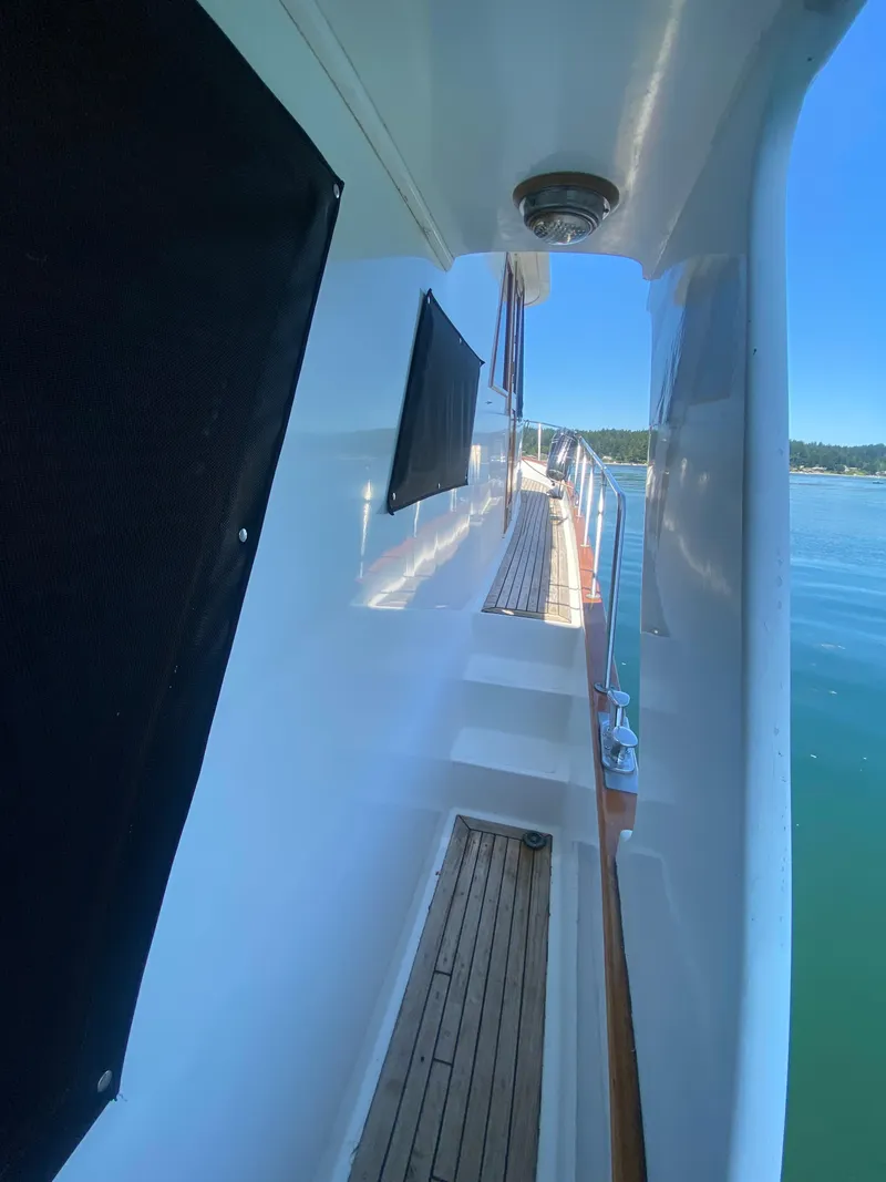 Slide: The Image of Side view of 1982 C & L Sea Ranger yacht with wooden deck and calm waters. - 8