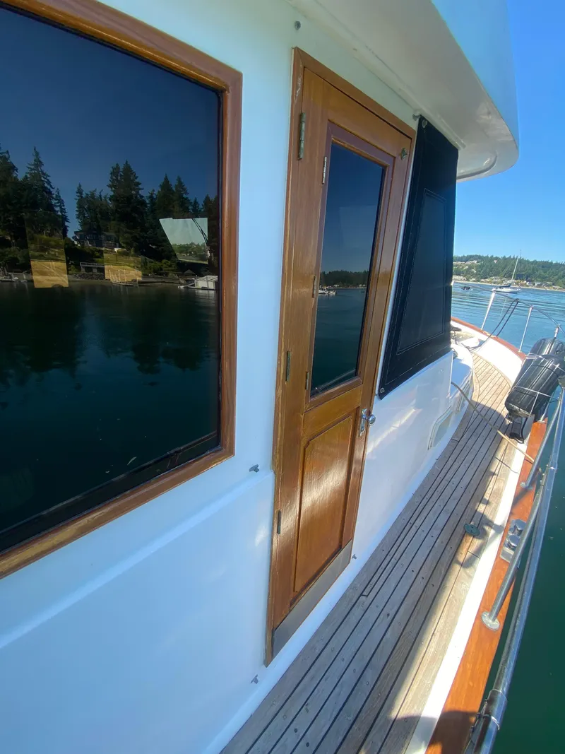 Slide: The Image of 1982 C & L Sea Ranger boat deck with wooden door and scenic water view. - 9