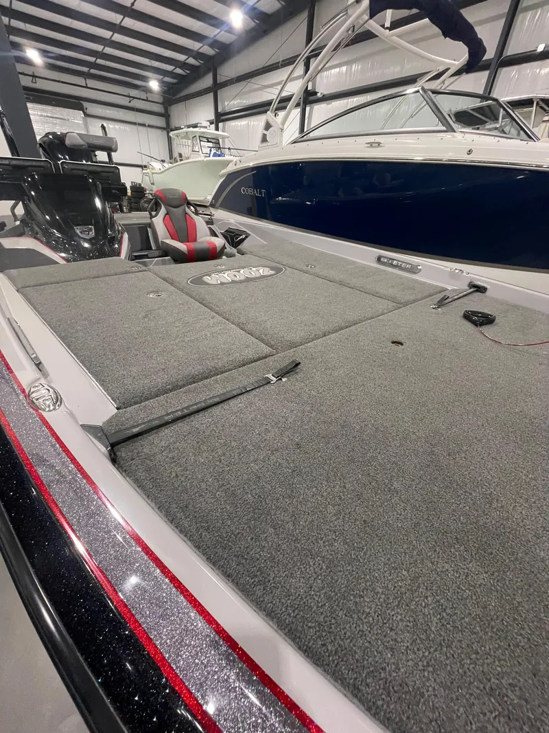 Slide: The Image of 2020 Skeeter FXR 21 Limited boat in showroom, featuring spacious deck and seating. - 6