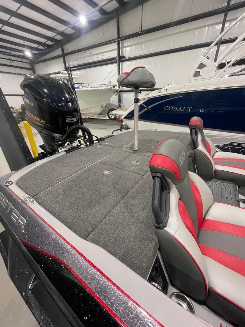 Slide: The Image of 2020 Skeeter FXR 21 Limited boat interior with red and gray seating in a showroom. - 7