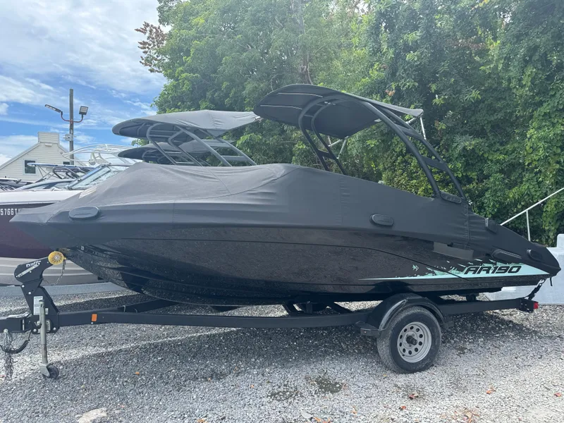 The Image of 2023 Yamaha AR190 boat with cover on trailer, parked outdoors. - 0