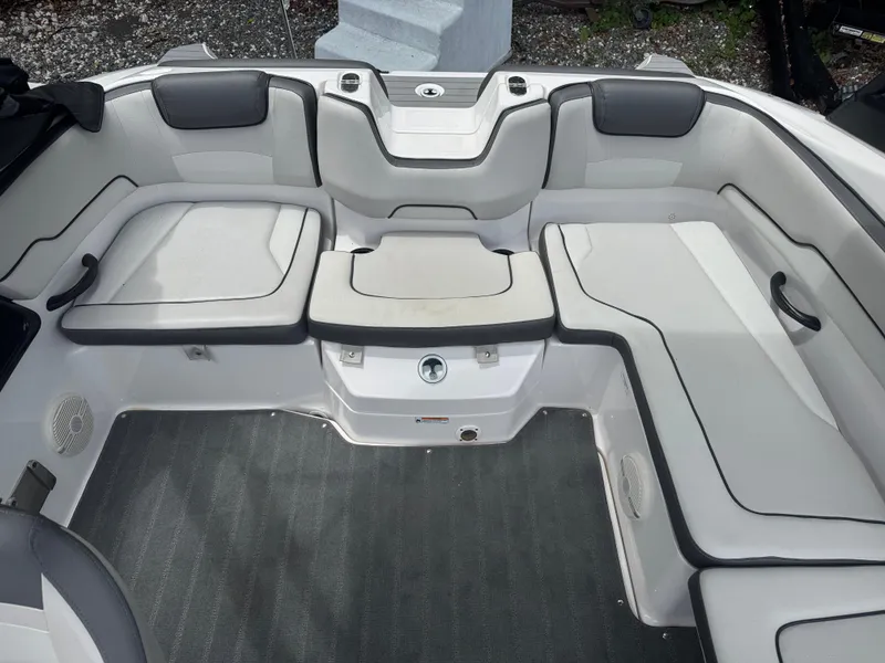 Slide: The Image of 2023 Yamaha AR190 boat interior with cushioned seating and gray flooring. - 11