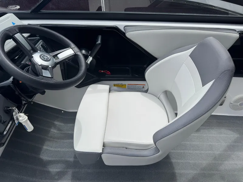 Slide: The Image of 2023 Yamaha AR190 boat interior with steering wheel and cushioned seat. - 12