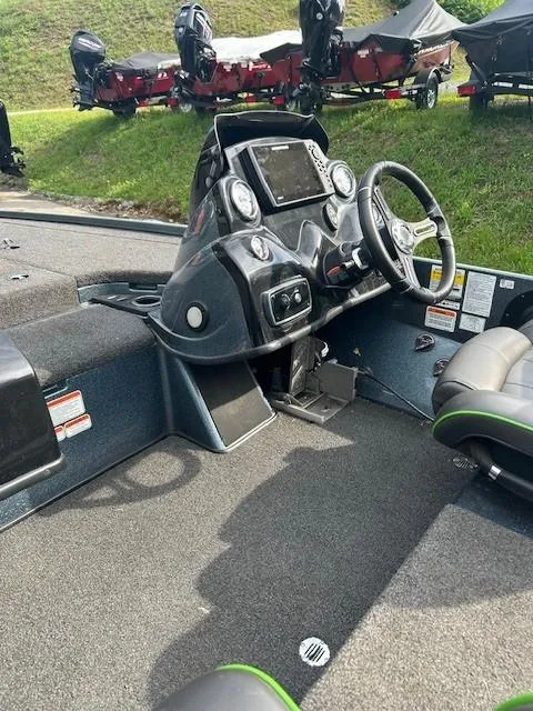Slide: The Image of 2018 Nitro Z19 boat cockpit with steering wheel and control panel, parked on grass. - 10