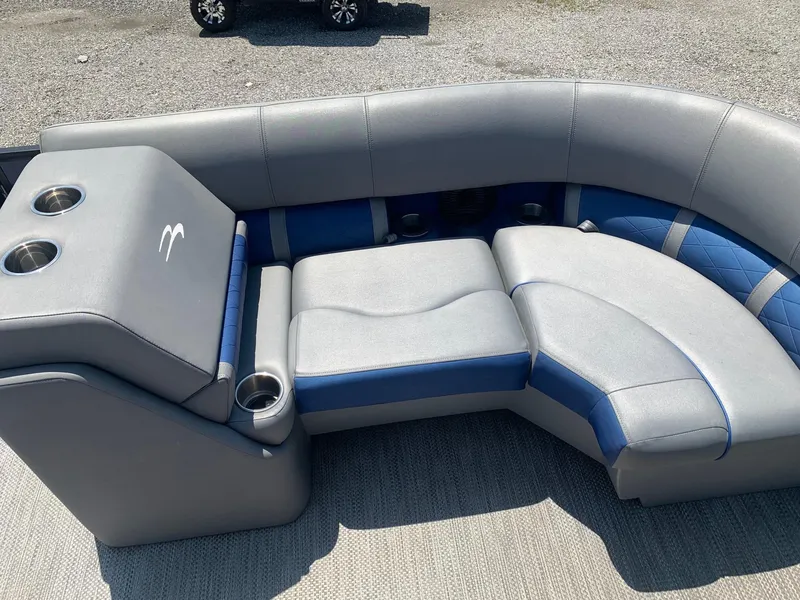 Slide: The Image of 2021 Bennington 24 LSR boat interior with gray and blue seating and cup holders. - 13