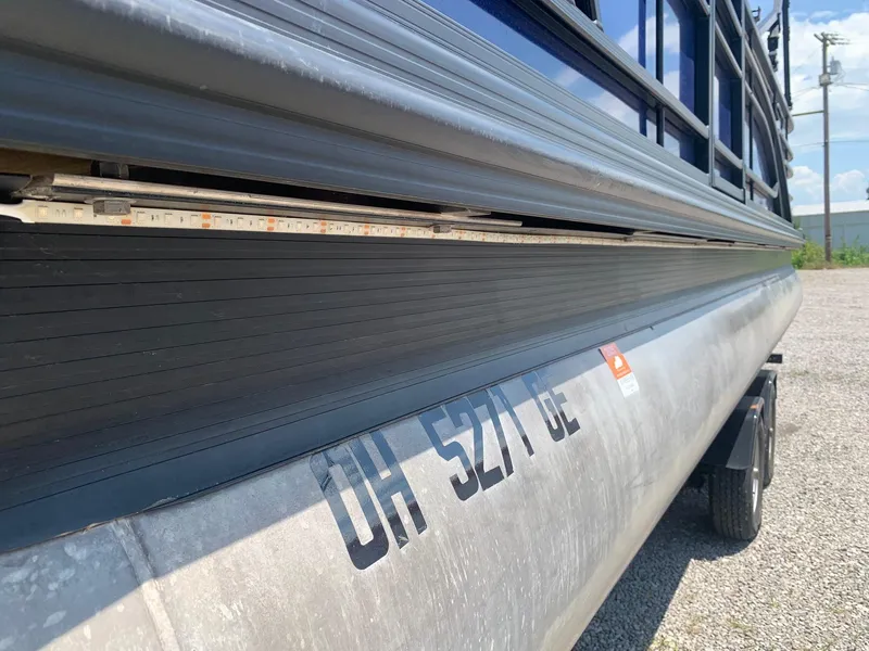 Slide: The Image of 2021 Bennington 24 LSR pontoon boat on trailer, side view with visible registration number. - 16