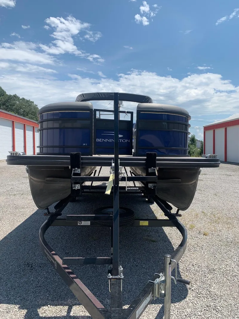 Slide: The Image of 2021 Bennington 24 LSR pontoon boat on trailer under a clear blue sky. - 2