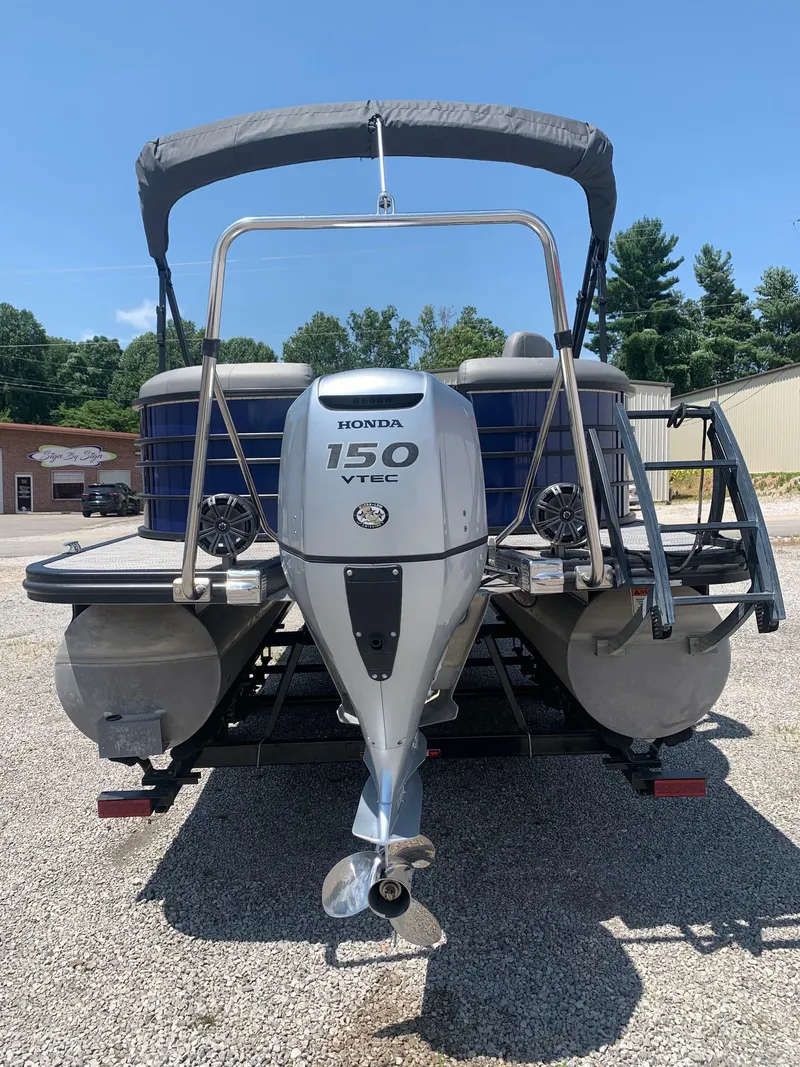 Slide: The Image of 2021 Bennington 24 LSR pontoon boat with Honda 150 VTEC engine, parked outdoors. - 3
