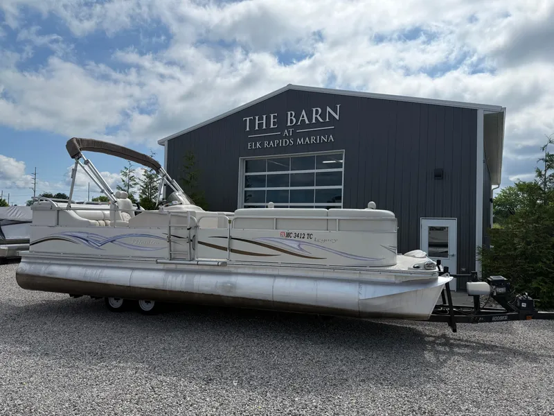 Slide: The Image of 2006 Manitou 24 Legacy pontoon boat at Elk Rapids Marina, parked on gravel. - 0