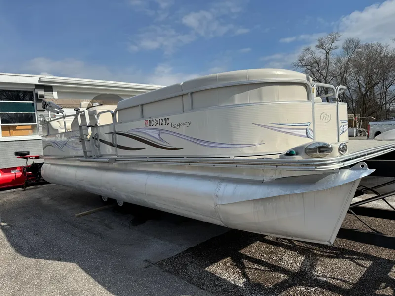Slide: The Image of 2006 Manitou 24 Legacy pontoon boat parked outdoors on a sunny day. - 10