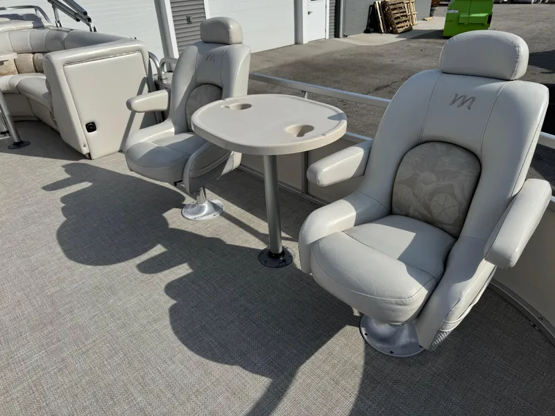 Slide: The Image of Luxury seating on 2006 Manitou 24 Legacy pontoon boat with table and cup holders. - 2