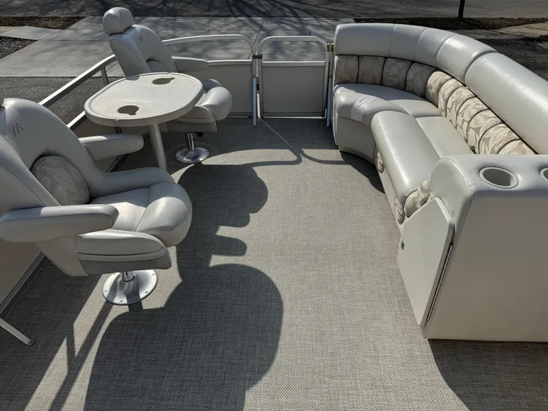 Slide: The Image of 2006 Manitou 24 Legacy pontoon boat interior with plush seating and table. - 3