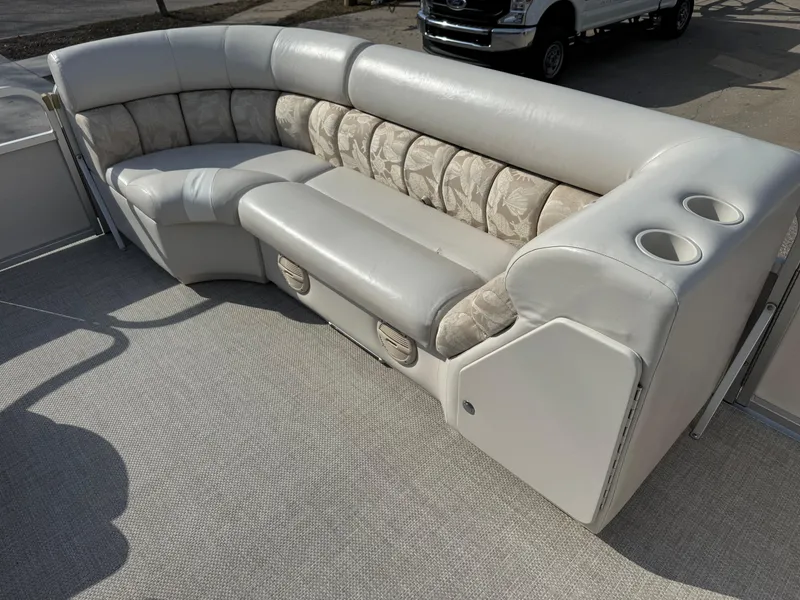 Slide: The Image of 2006 Manitou 24 Legacy boat interior with cushioned seating and cup holders. - 4