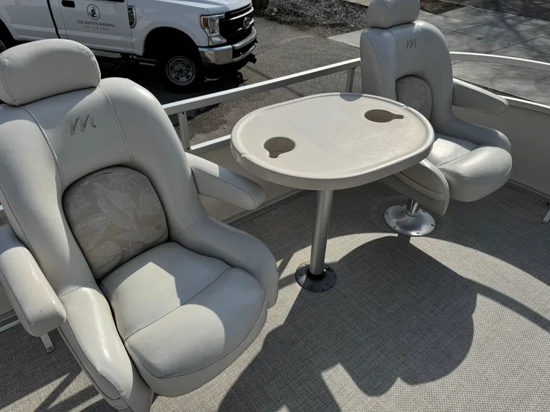 Slide: The Image of 2006 Manitou 24 Legacy boat interior with two cushioned seats and a table. - 5