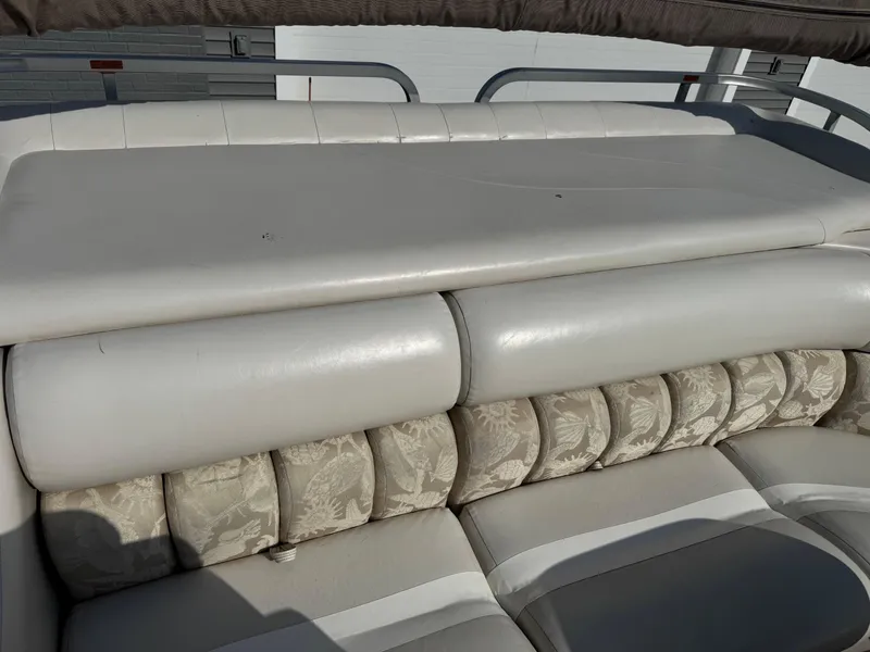Slide: The Image of 2006 Manitou 24 Legacy boat seating with white and patterned upholstery. - 9