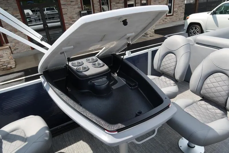 Slide: The Image of 2024 Bennington L Entertainment 23 LPD boat with open storage compartment and cup holders. - 17