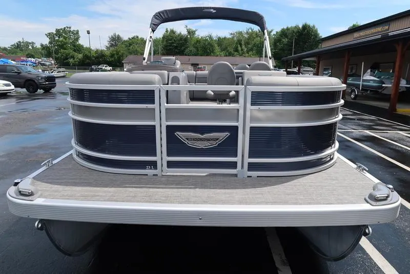 Slide: The Image of 2024 Bennington L Entertainment 23 LPD pontoon boat, front view in a parking lot. - 2