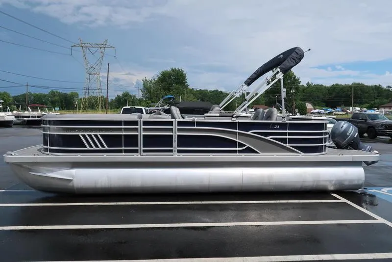 Slide: The Image of 2024 Bennington L Entertainment 23 LPD pontoon boat parked on wet pavement. - 5