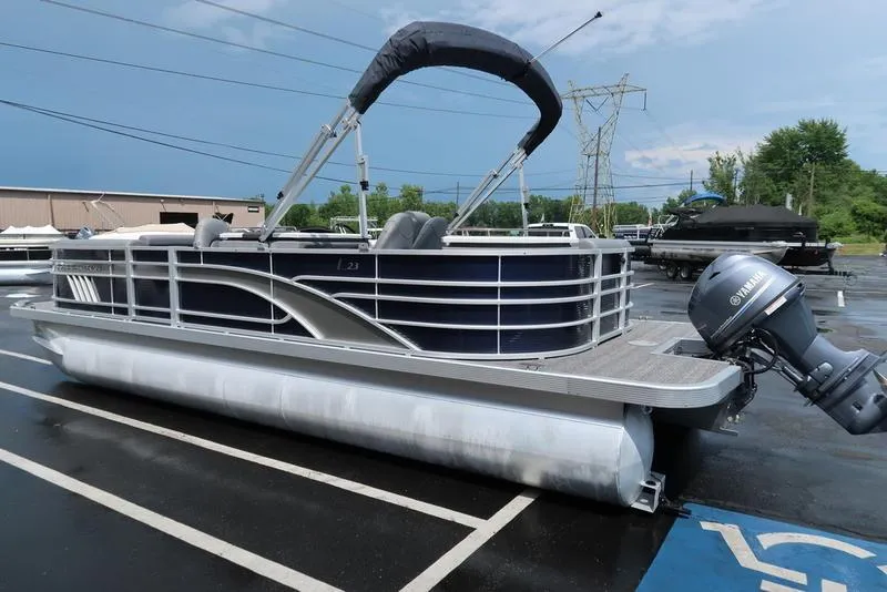 Slide: The Image of 2024 Bennington L Entertainment 23 LPD pontoon boat with Yamaha outboard motor in parking lot. - 8