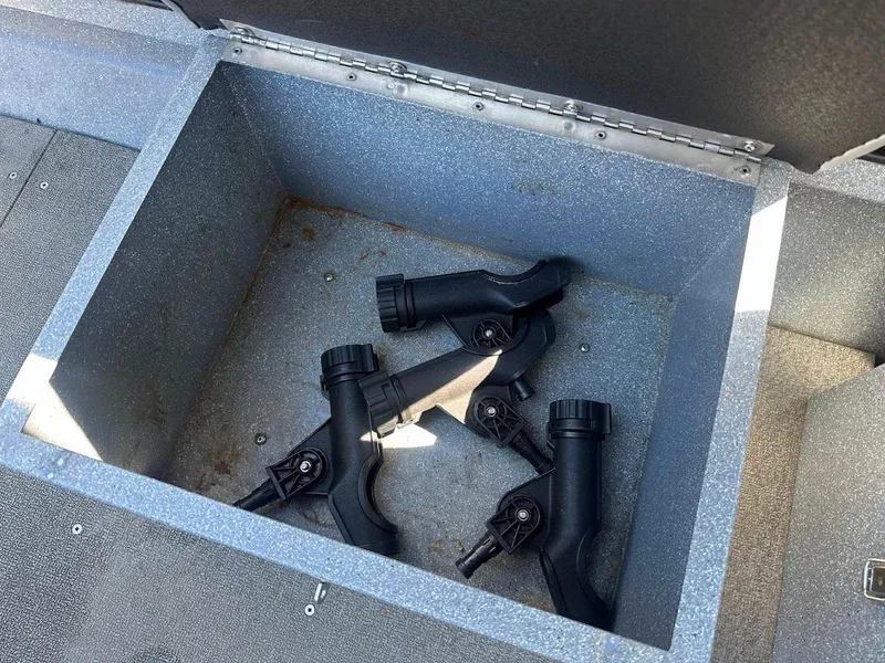 Slide: The Image of Open storage compartment with black rod holders in a 2008 Jetcraft 1925 Adventurer boat. - 24