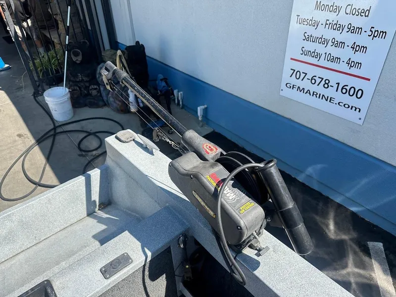 Slide: The Image of Jetcraft 1925 Adventurer boat detail with fishing equipment, parked near a marine service shop. - 31