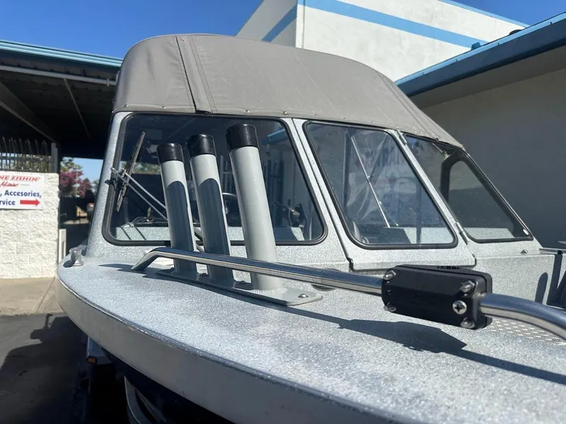 Slide: The Image of 2008 Jetcraft 1925 Adventurer boat with canopy and rod holders, parked outdoors. - 33