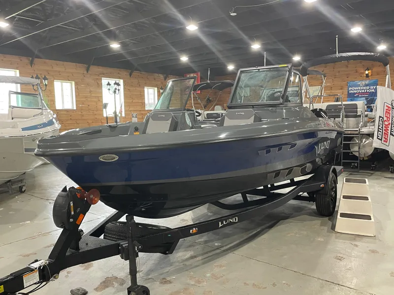 Slide: The Image of 2025 Lund 185 Impact GL boat displayed indoors on a trailer. - 3