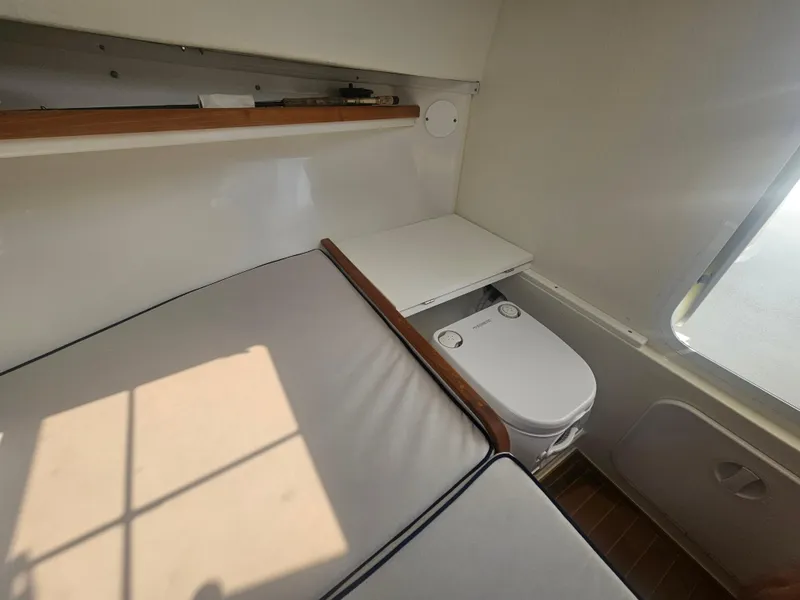 Slide: The Image of 2019 Eastern 248 Explorer cabin interior with compact toilet and cushioned seating. - 11