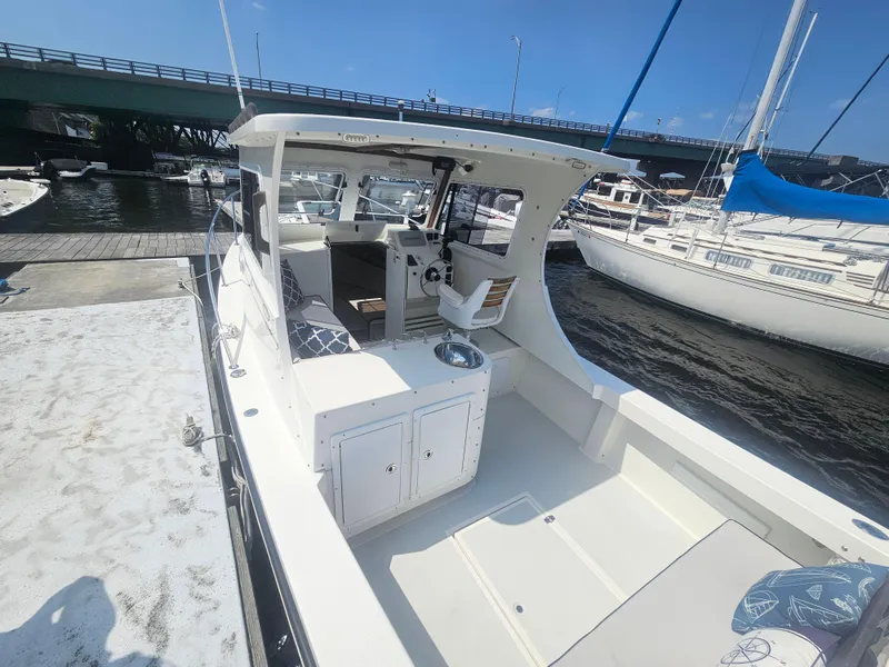 Slide: The Image of 2019 Eastern 248 Explorer boat docked near a bridge on a sunny day. - 15