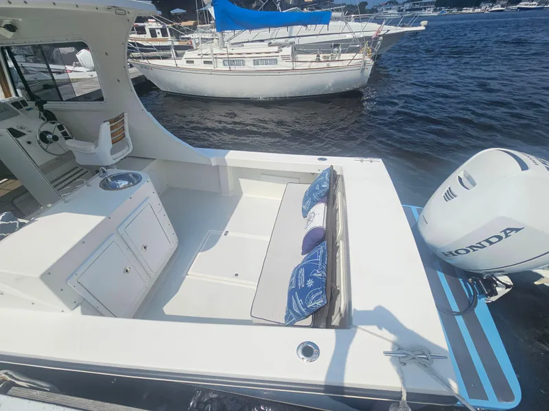 Slide: The Image of 2019 Eastern 248 Explorer boat with Honda outboard motor, docked near other boats. - 16